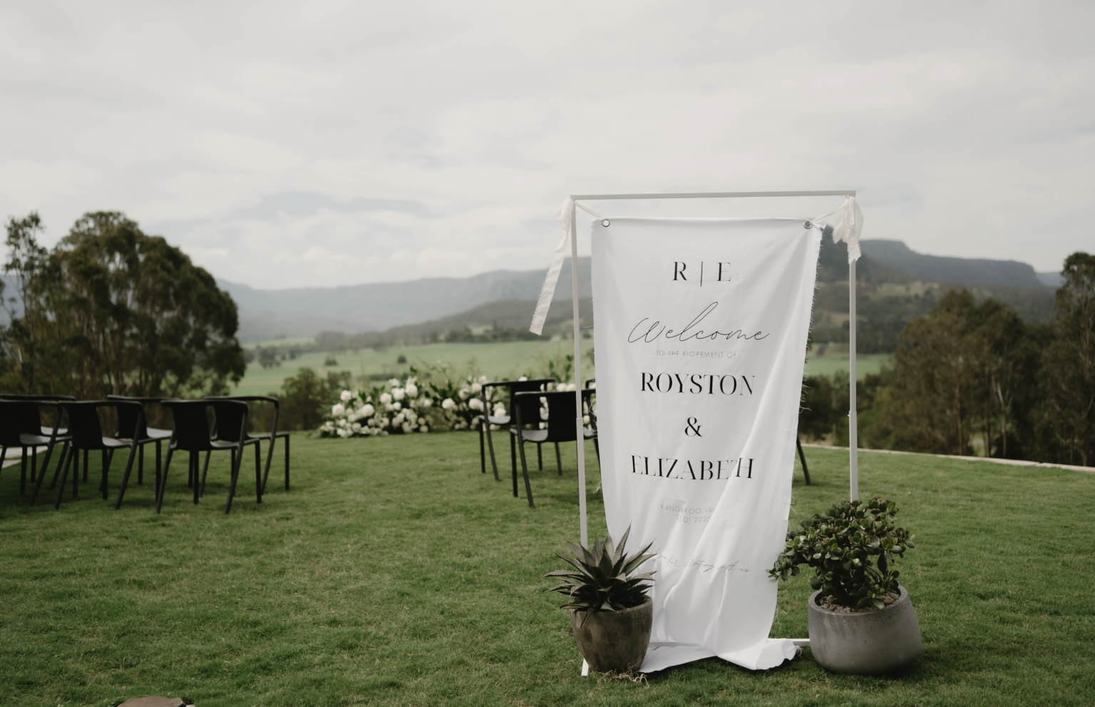 Welcome sign and reception tables set on the lawn at La Belle Vallée